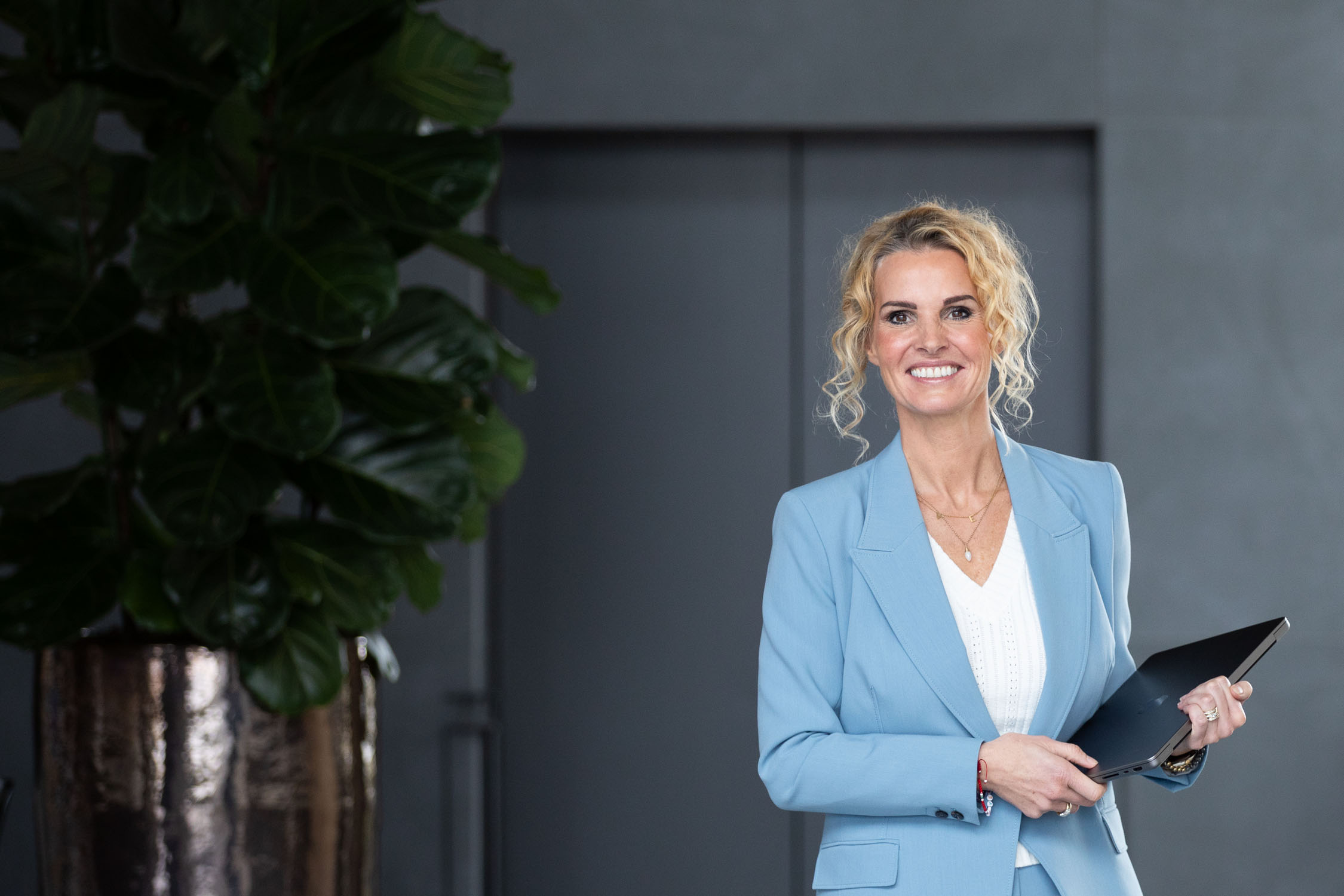 Petra van de Laarschot met een tablet in een lichte kantoorruimte
