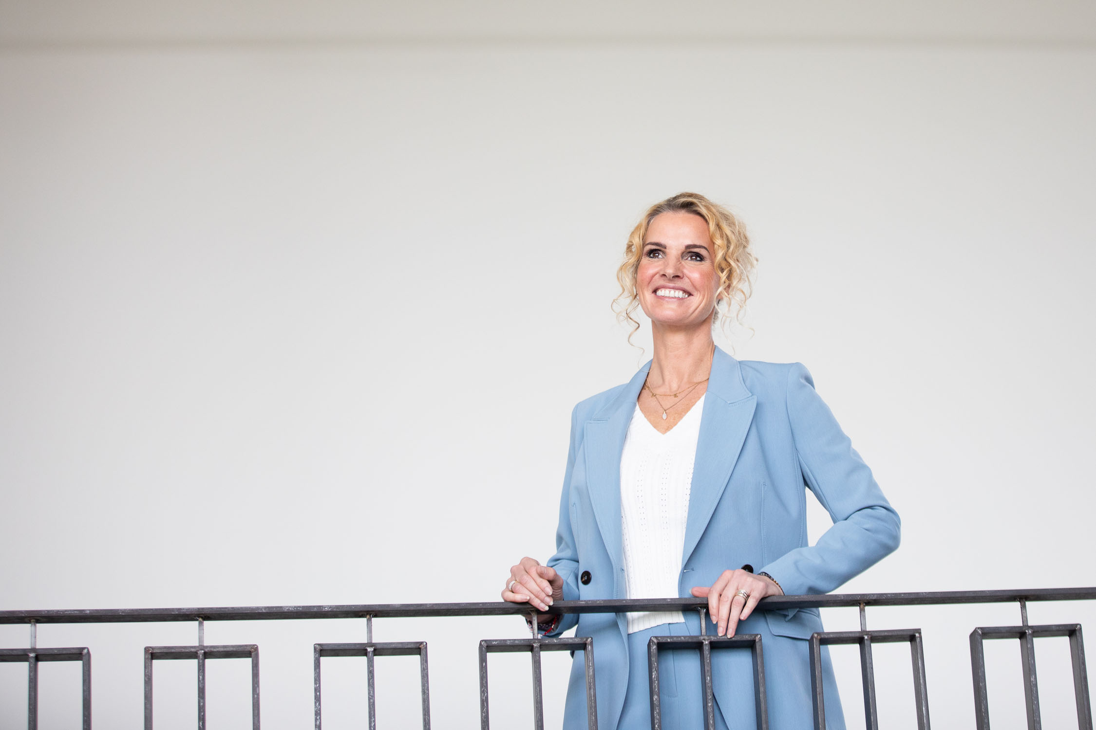 Petra van de Laarschot, coach voor persoonlijk leiderschap, staat ontspannen aan een balustrade