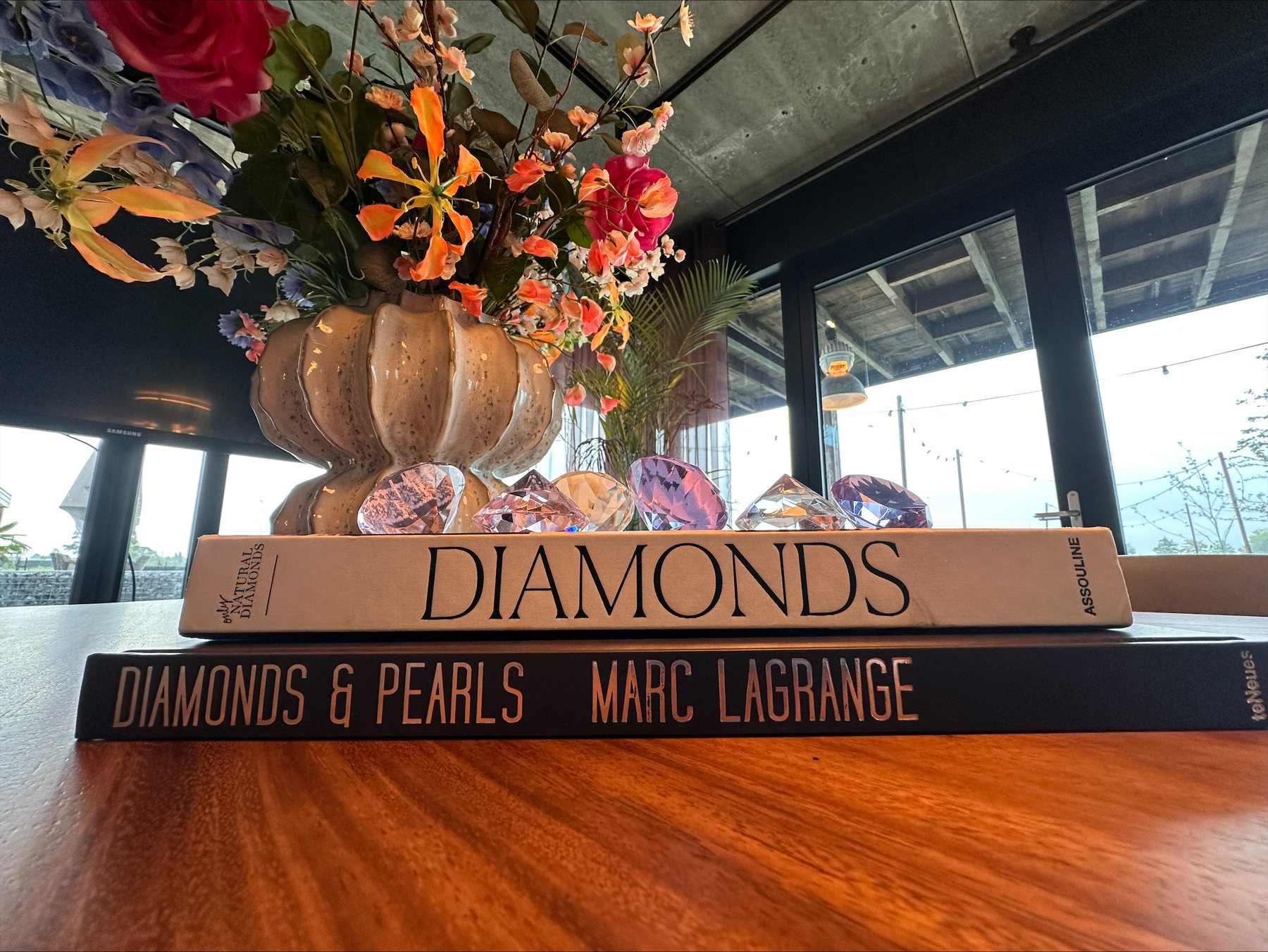Boek Diamonds en een vaas met bloemen op de tafel in het kantoor van DiamondForce