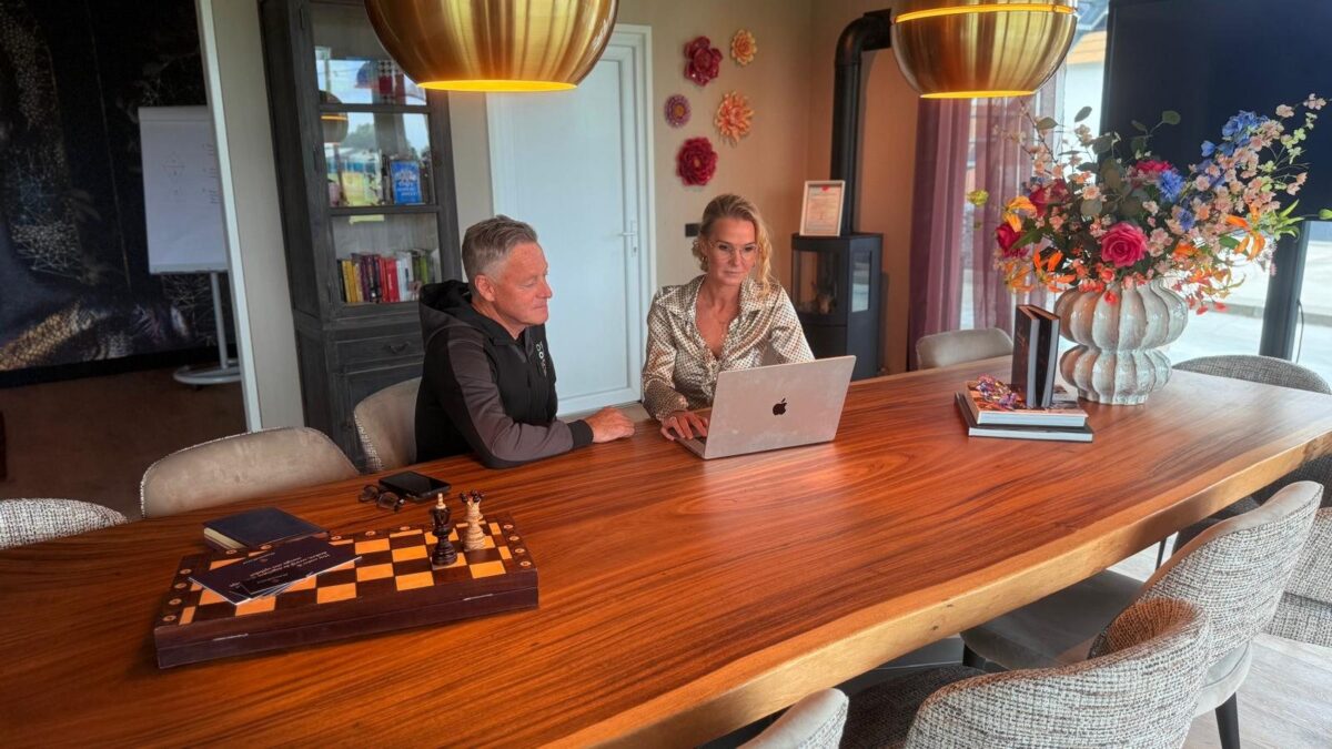 Petra van de Laarschot in gesprek met een cliënt aan de grote tafel in haar kantoor